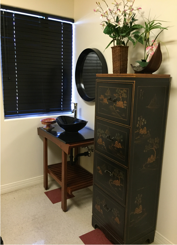 MomDoc Women for Women Scottsdale living-room corner with dark Asian-motif cabinet and decorative plants