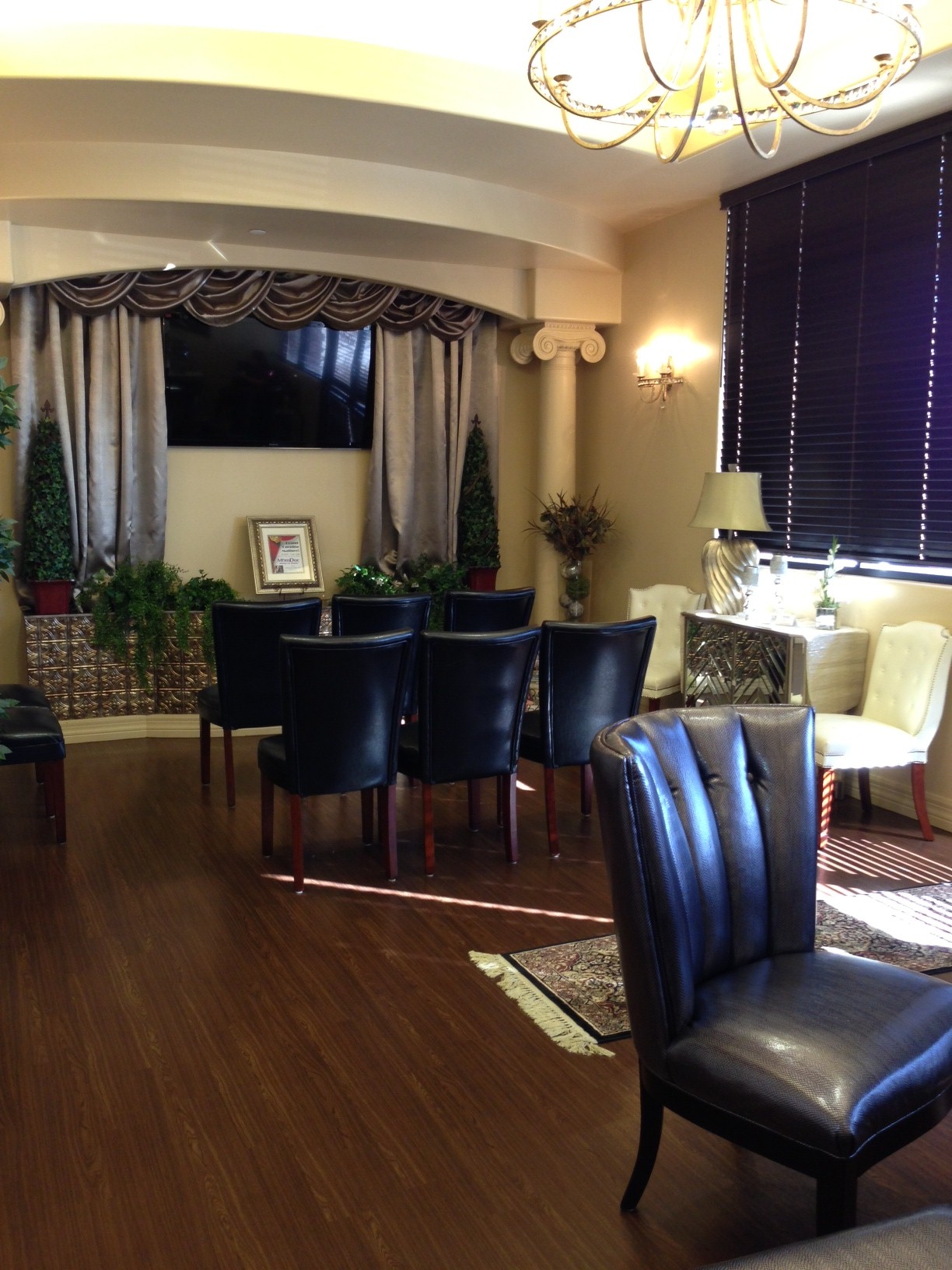 Mi Doctora Southern living-room with leather chairs, columns, and chandelier