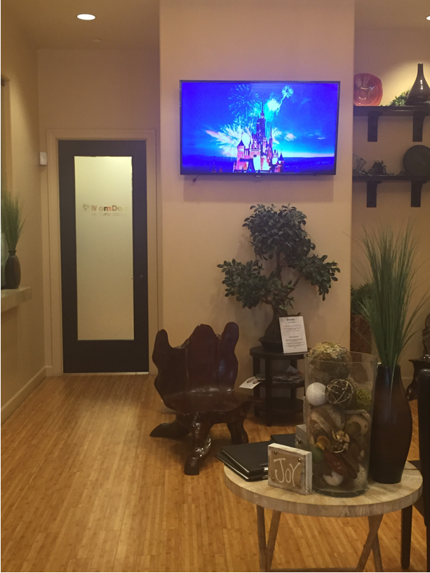 MomDoc Women for Women Tempe living-room with mounted TV, plants, and natural-tone seating